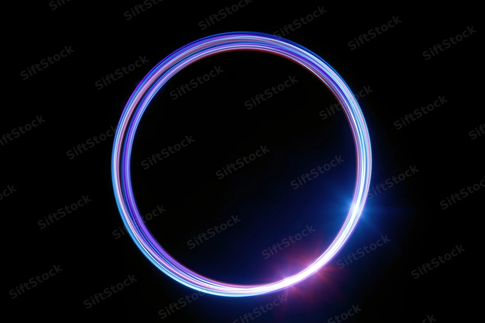 Glowing circular light trail formed by long-exposure light painting against black background