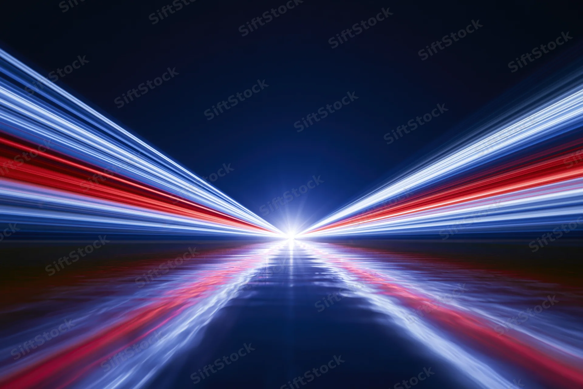 Light trails converging at a vanishing point on a dark road at night