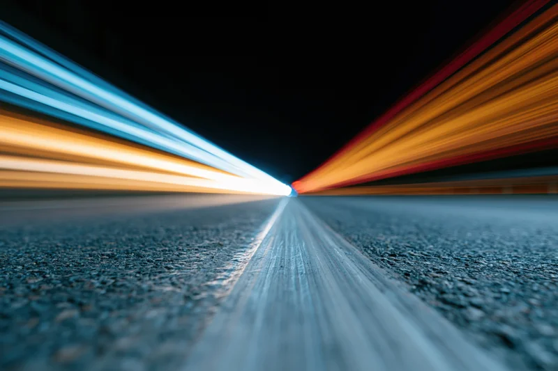 Long-exposure night highway with light streaks from moving vehicles viewed from low road level