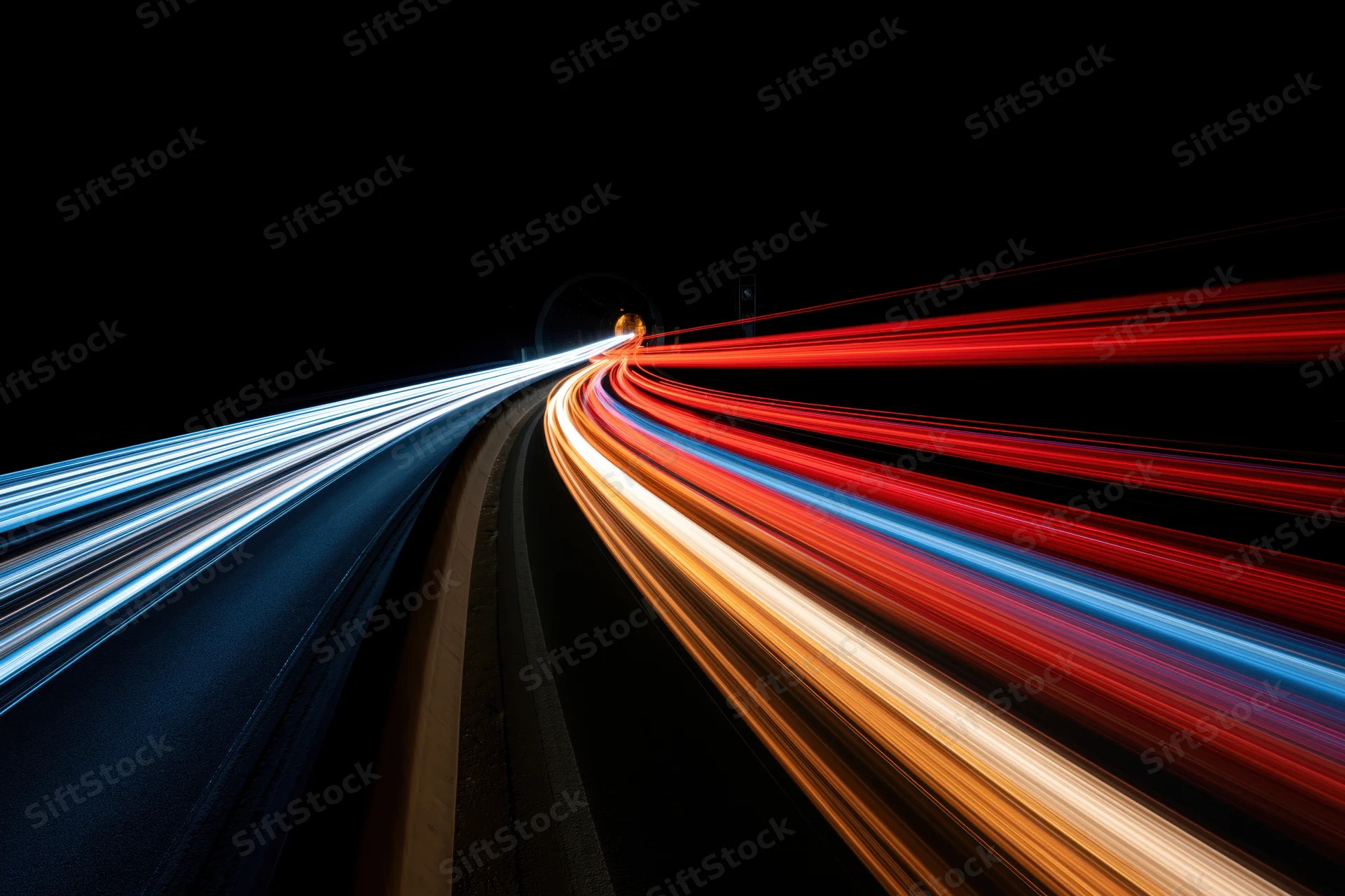 Long-exposure night view of curving highway with streaking vehicle lights in motion