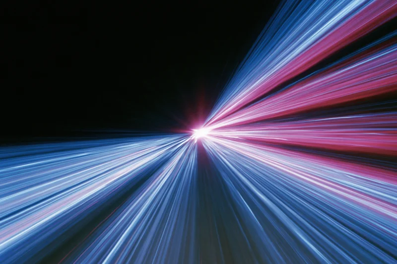 Radiating light streaks from city street traffic at night creating dynamic motion blur
