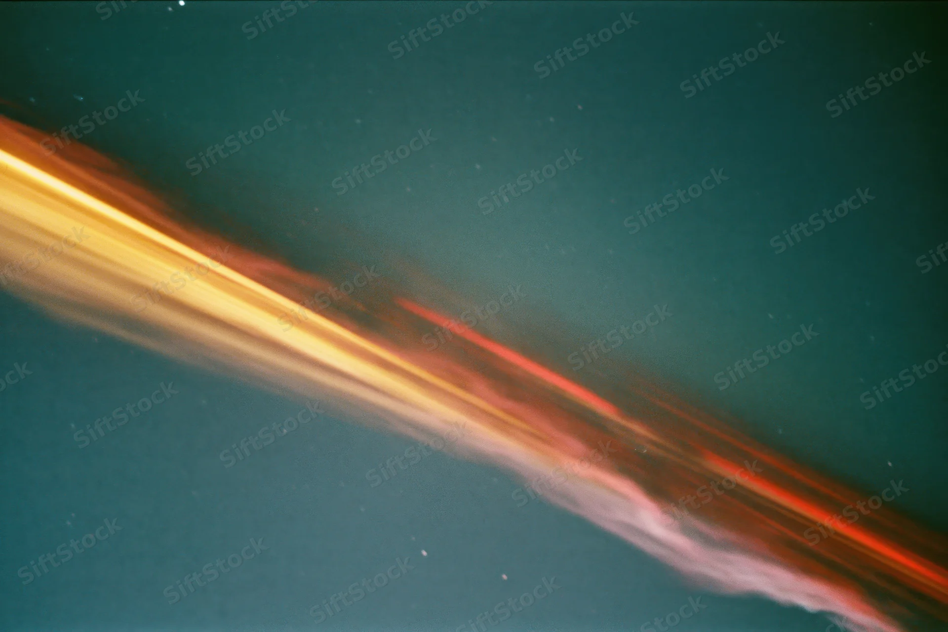 Long-exposure night sky with sweeping light streaks and scattered stars