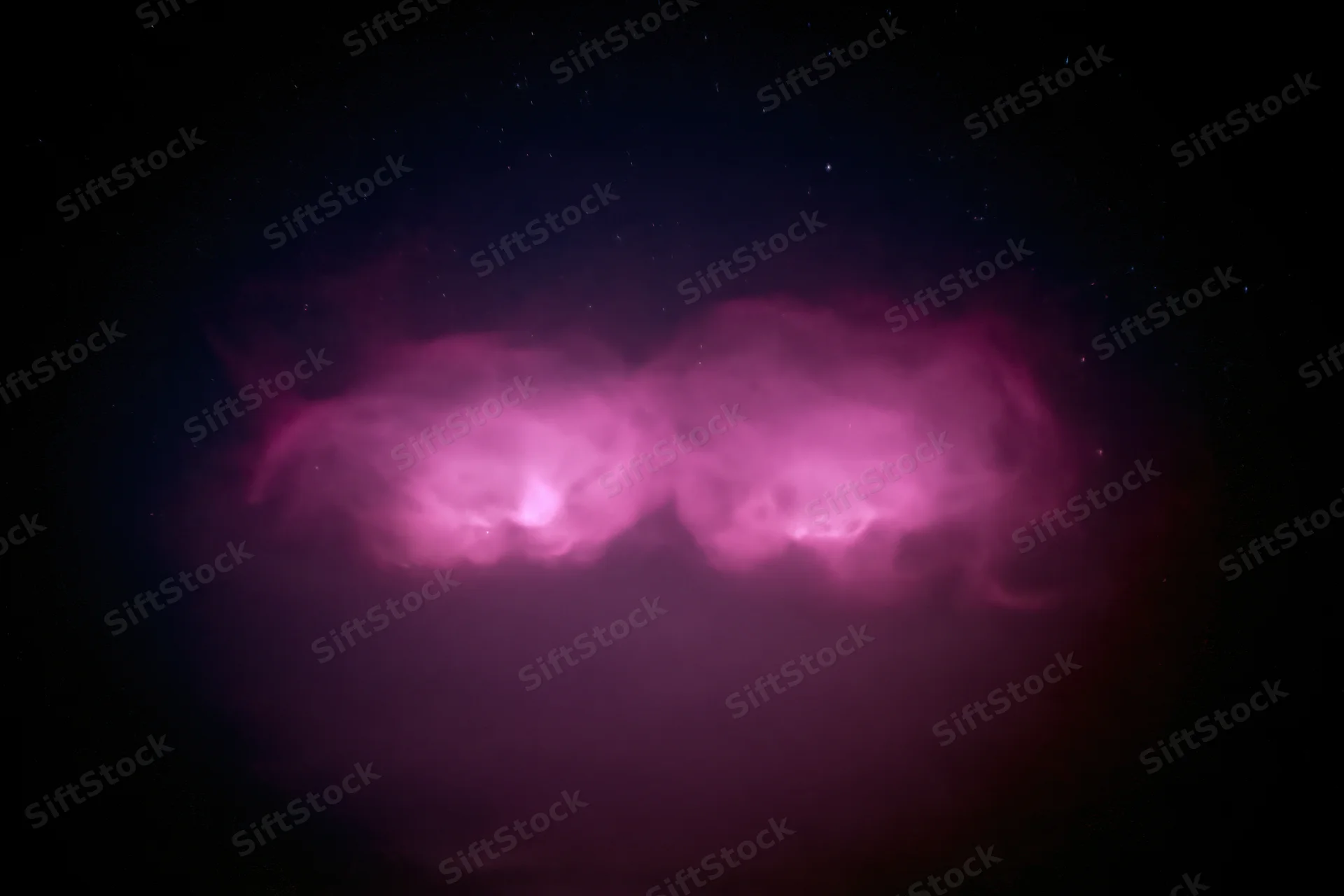 Two glowing magenta-pink cloud formations in the night sky
