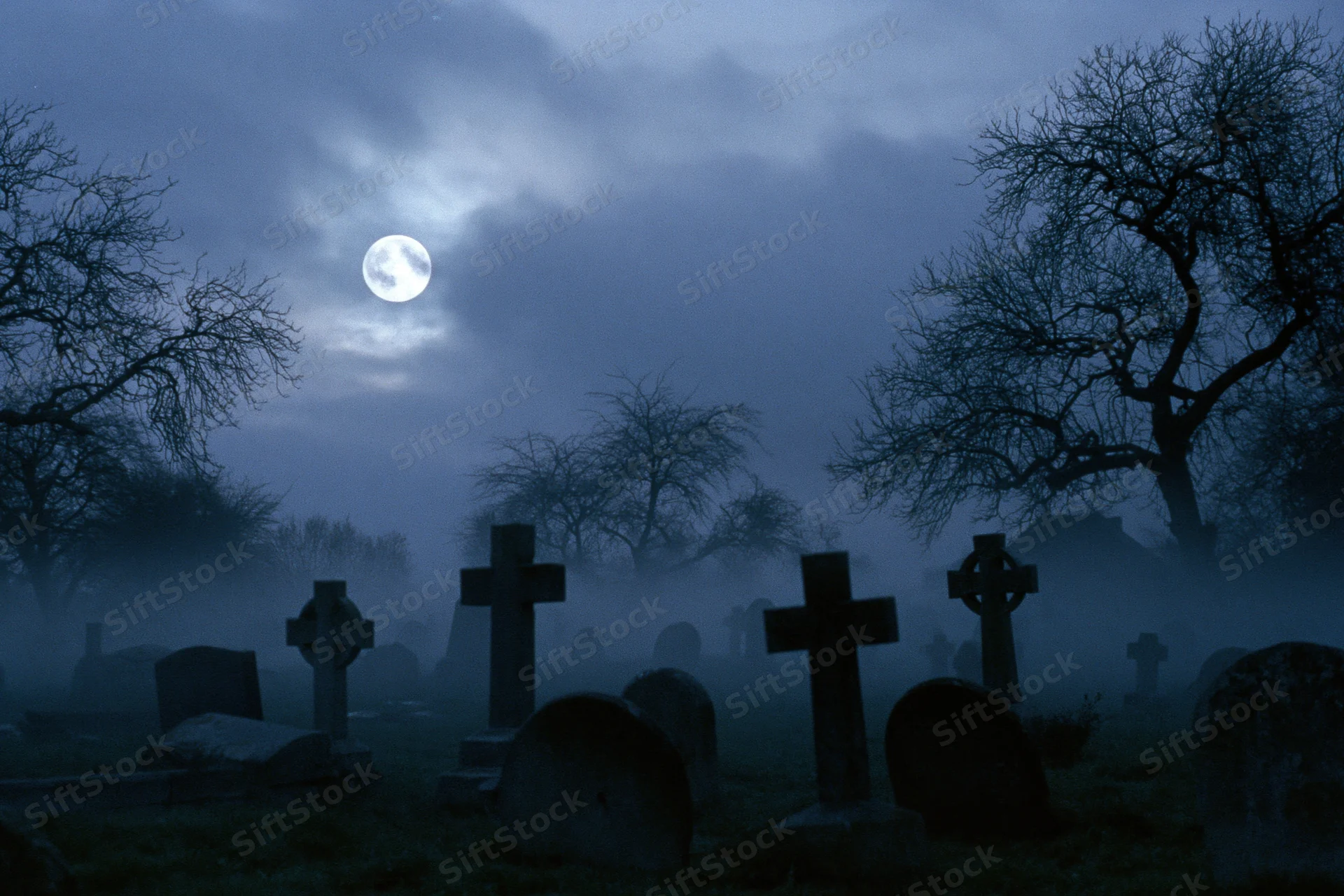 Old graveyard with weathered stone crosses and tombs under a full moon at night in fog