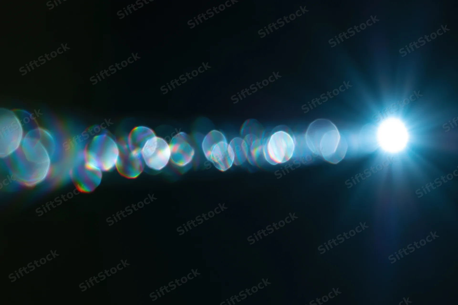 Bright lens flare with circular bokeh lights on a dark background