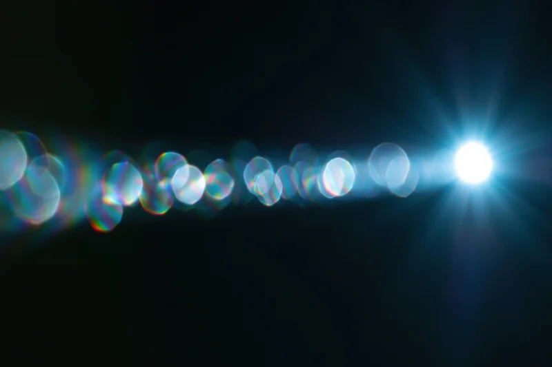 Bright lens flare with circular bokeh lights on a dark background