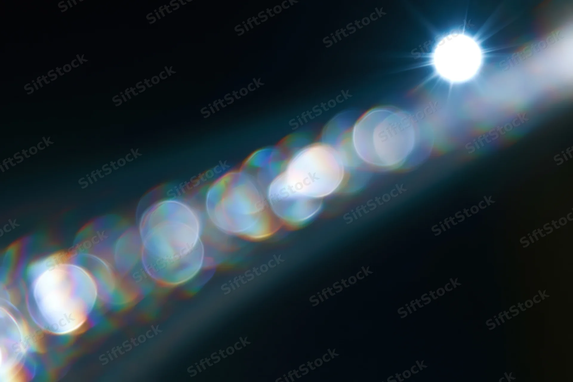 Bright lens flare with circular bokeh lights on a dark background