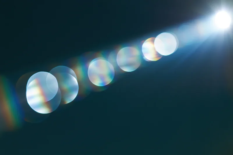 Bright lens flare with circular bokeh lights on a dark background
