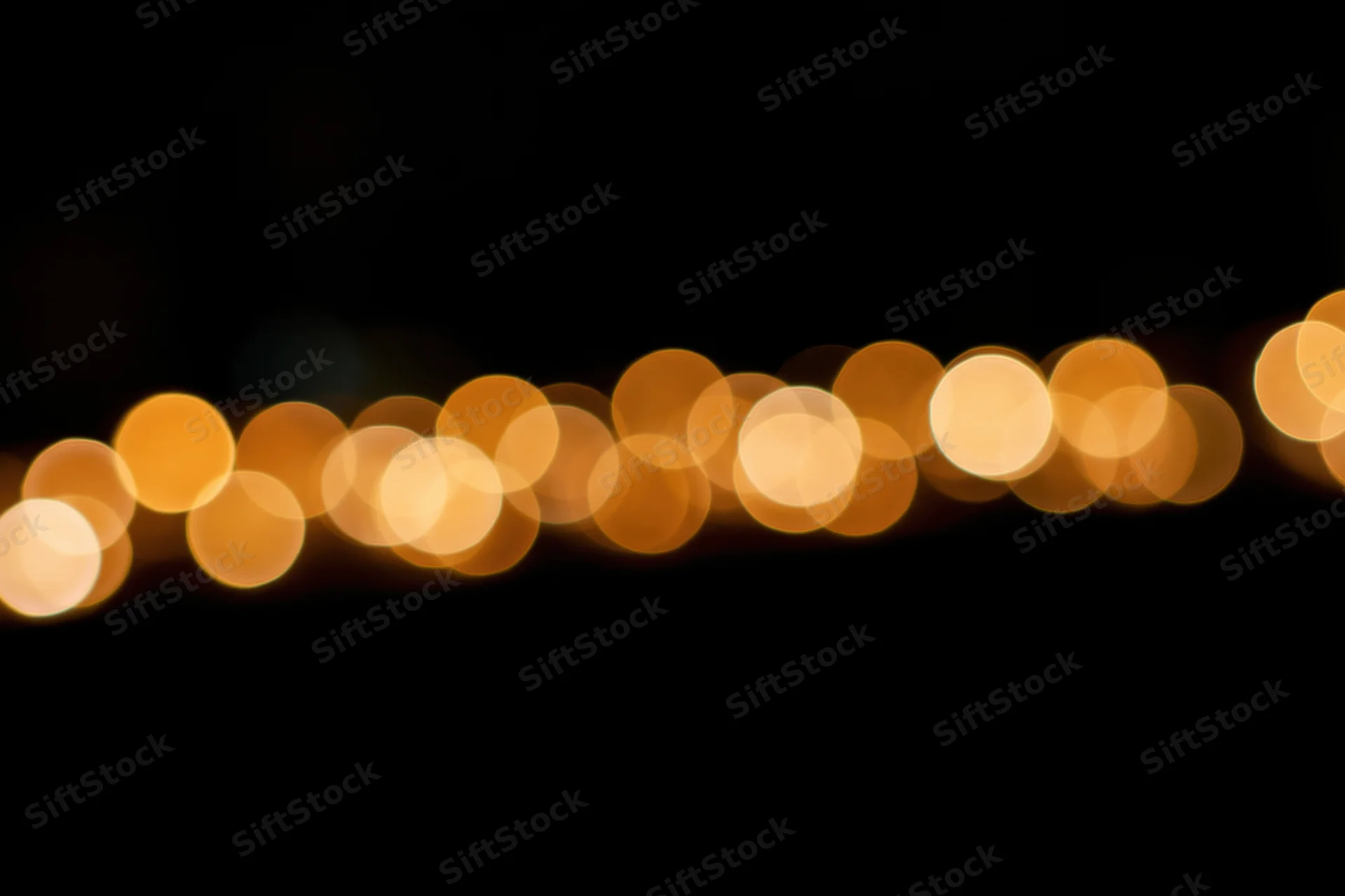 Golden bokeh circles scattered across the upper portion of a dark background