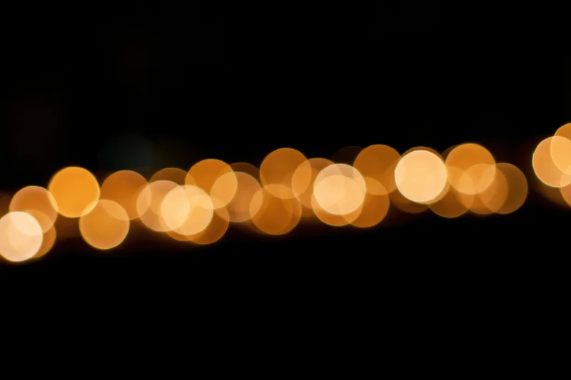 Golden bokeh circles scattered across the upper portion of a dark background