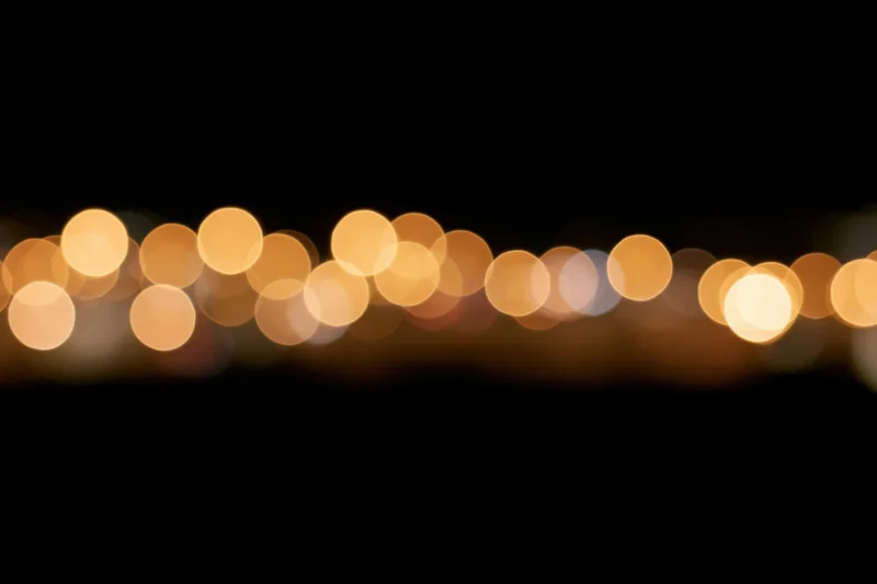 Golden bokeh circles scattered across the upper portion of a dark background