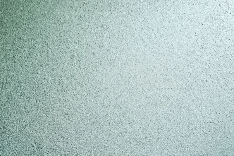 Plain painted wall surface filling the frame with smooth texture and light green color