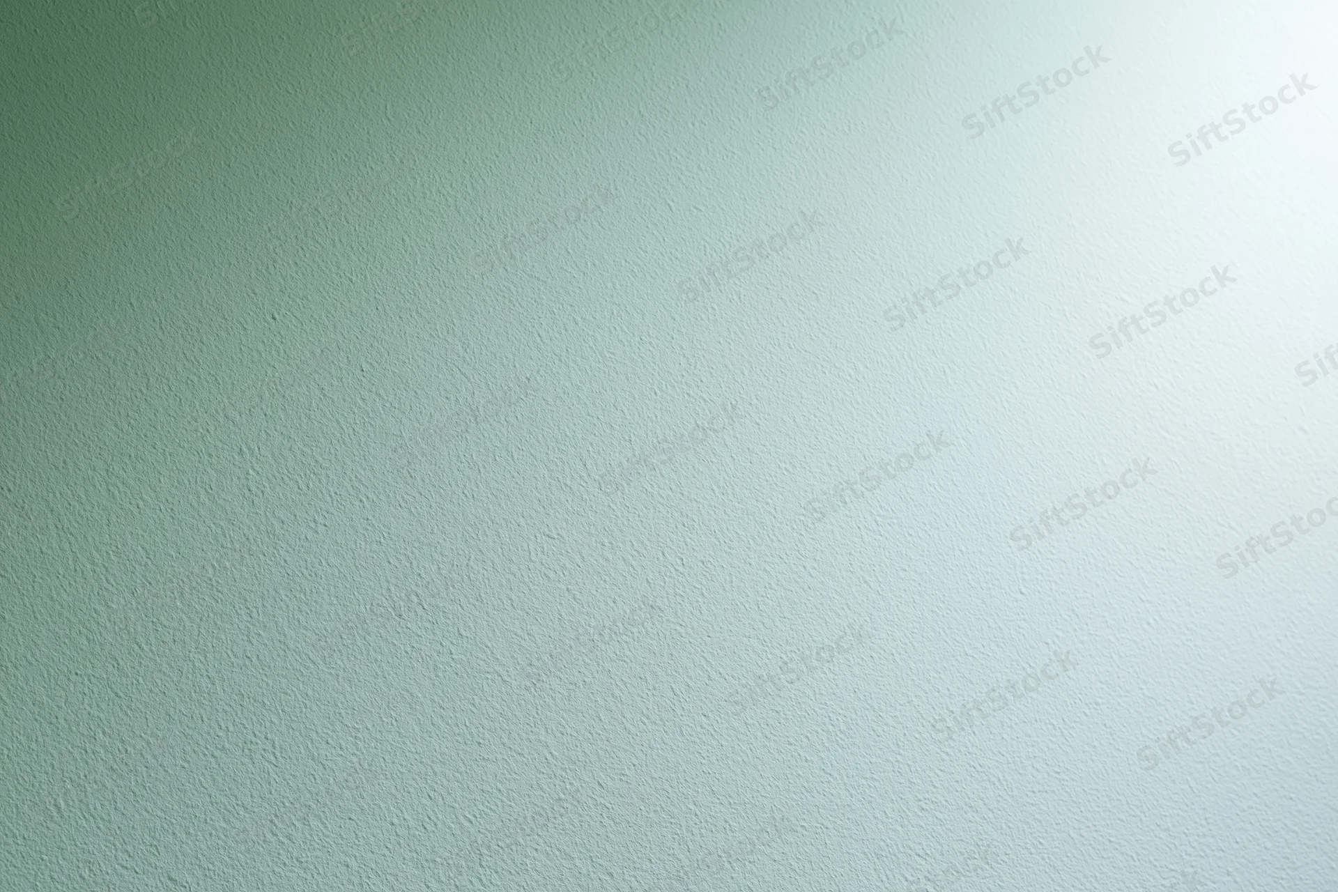 Smooth painted wall surface filling the frame with light green to white gradient and subtle texture