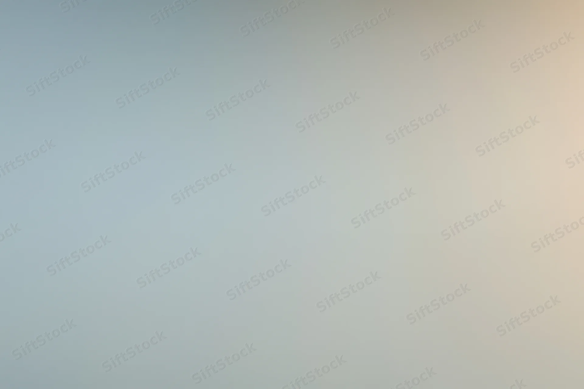 Smooth gradient surface transitioning from cool gray to warm beige in a studio backdrop