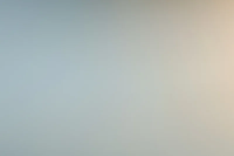 Smooth gradient surface transitioning from cool gray to warm beige in a studio backdrop