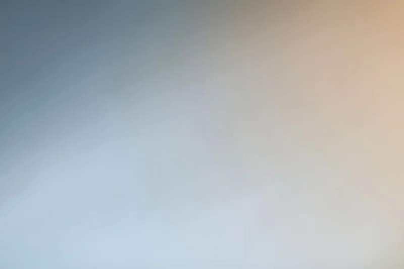 Smooth color gradient transitioning from blue to beige across a plain studio backdrop