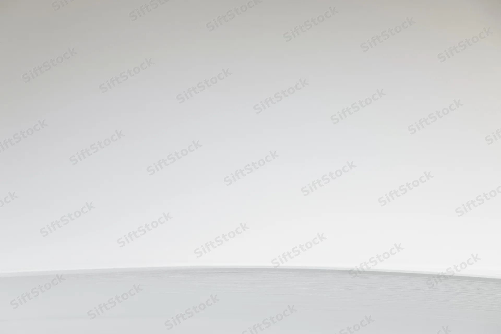 Plain white-to-light-grey gradient background in empty studio space