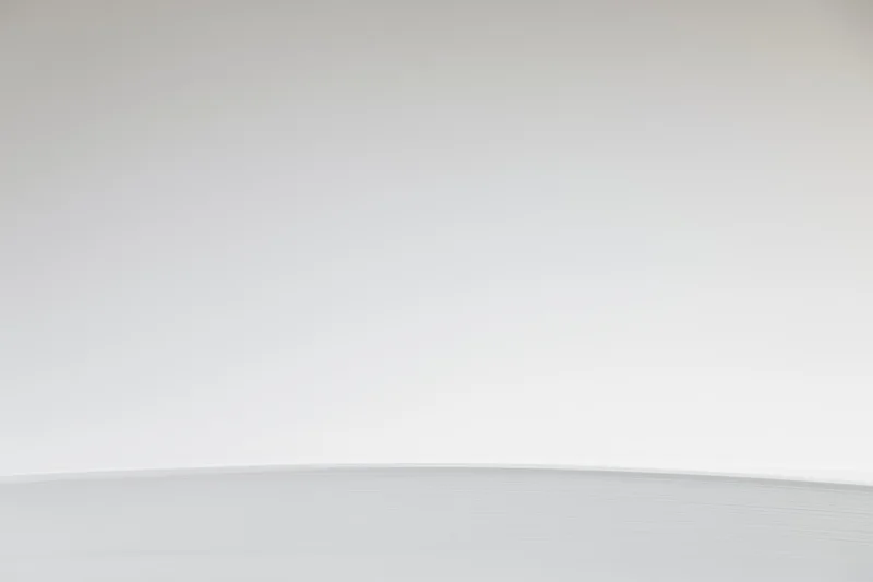 Plain white-to-light-grey gradient background in empty studio space