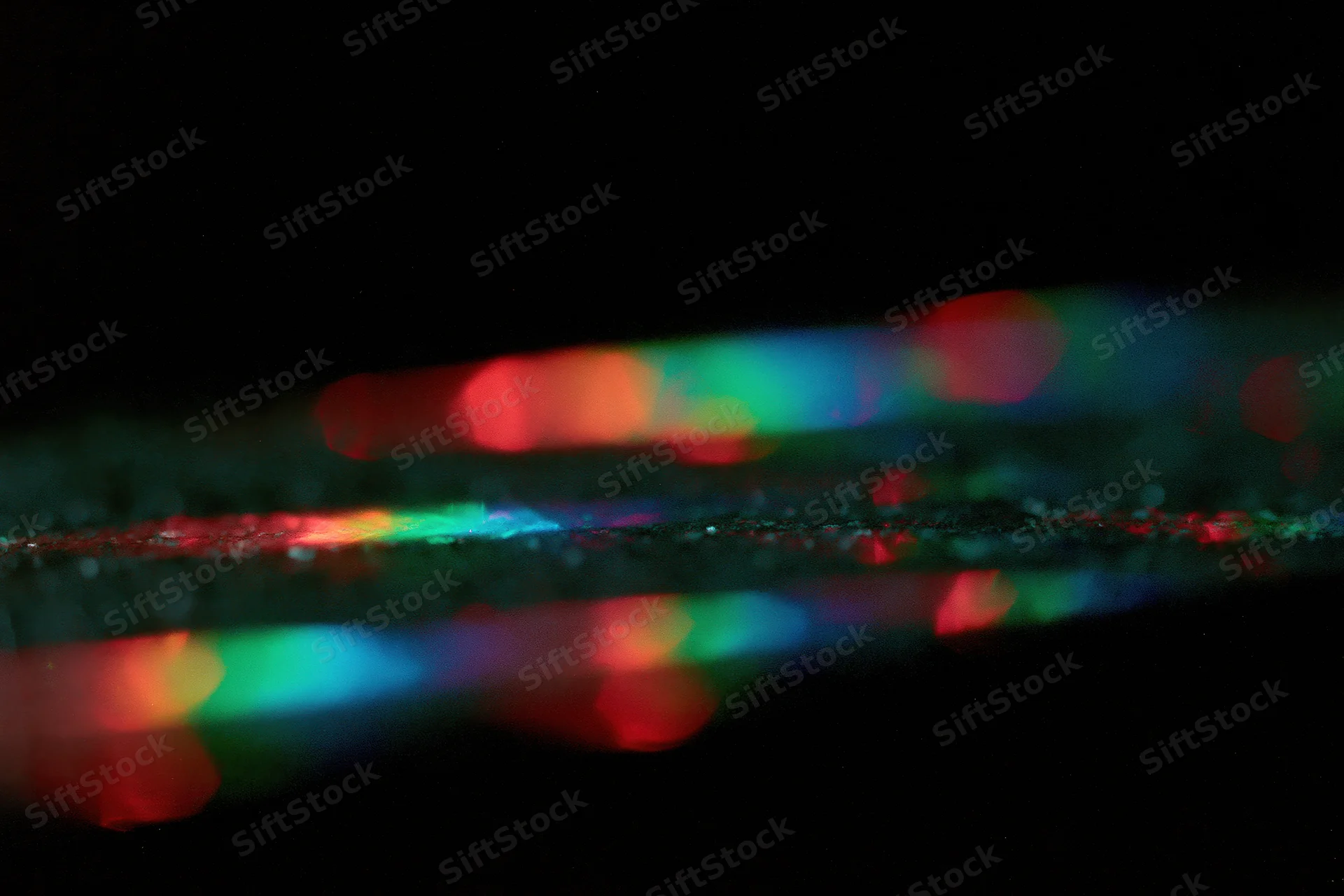 Prismatic light leaks scattered across a pure black background