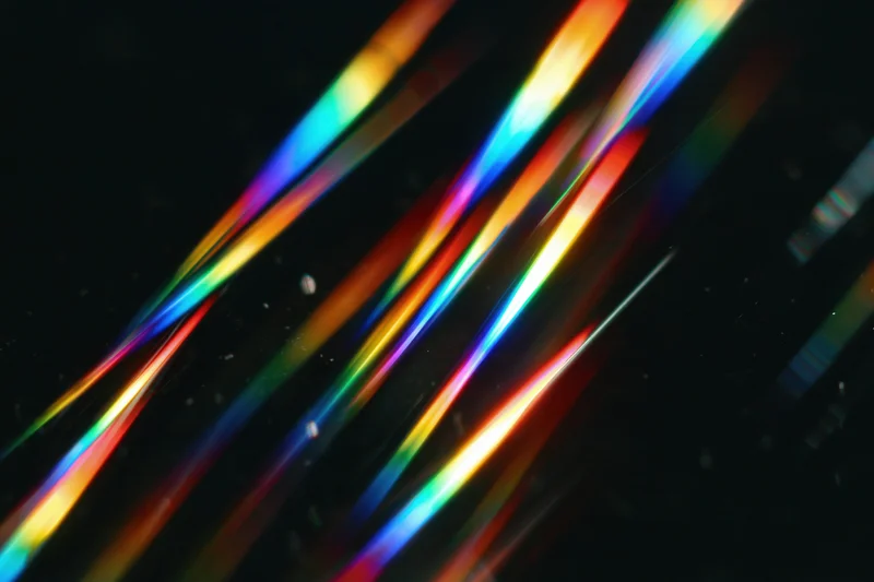 Prismatic light streaks scattered diagonally across dark background
