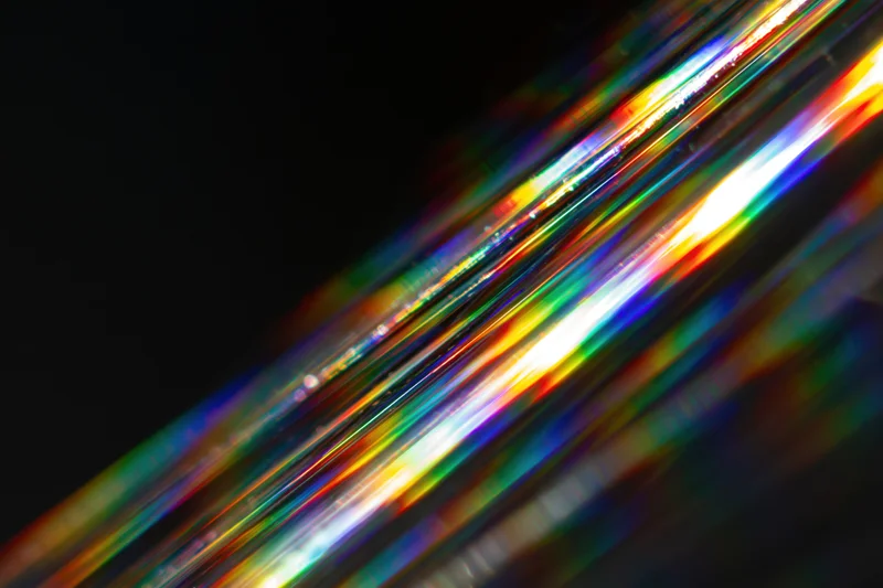 Prismatic light streaks scattered diagonally across dark background