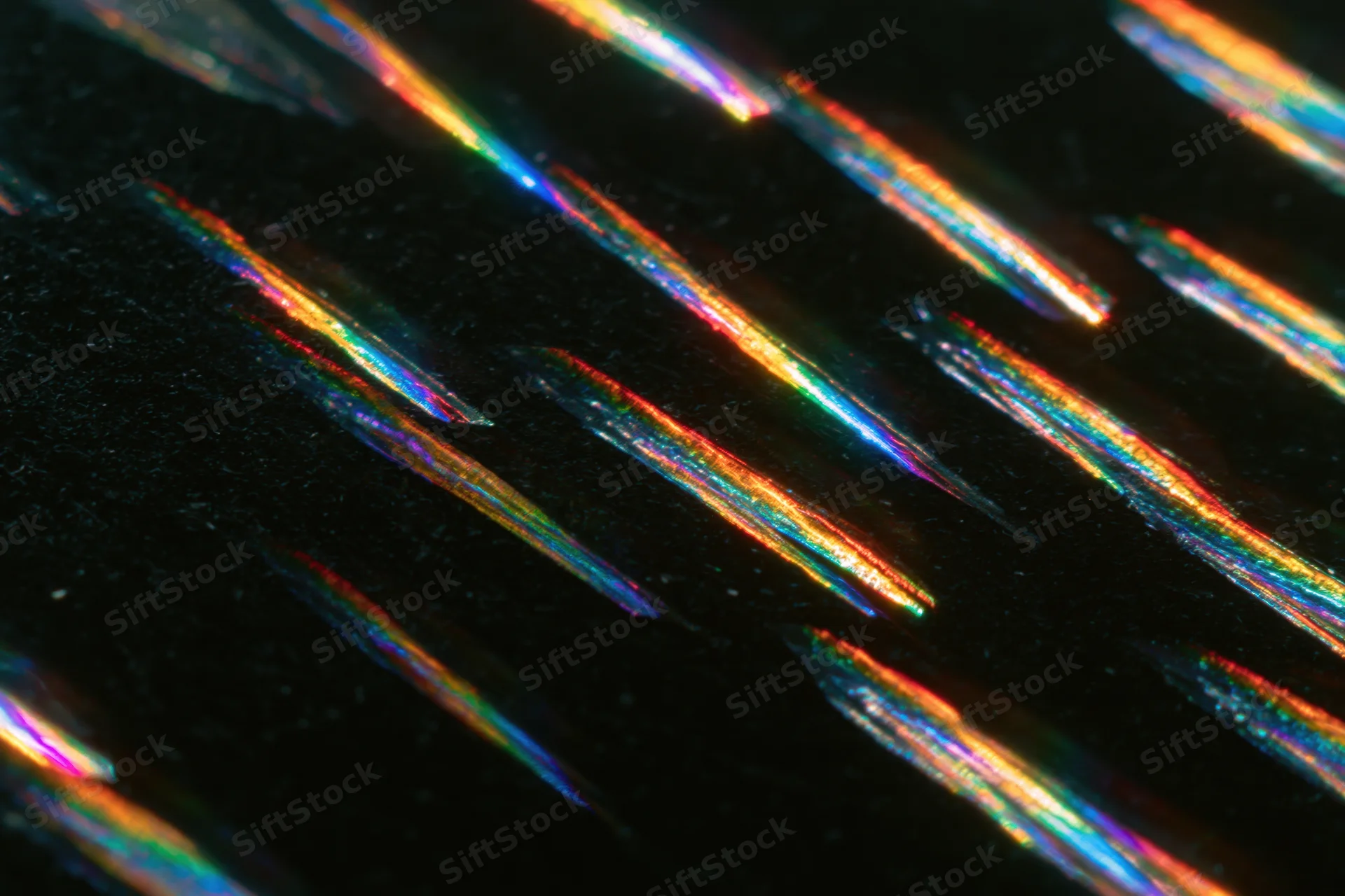 Prismatic light streaks arranged diagonally across a dark surface