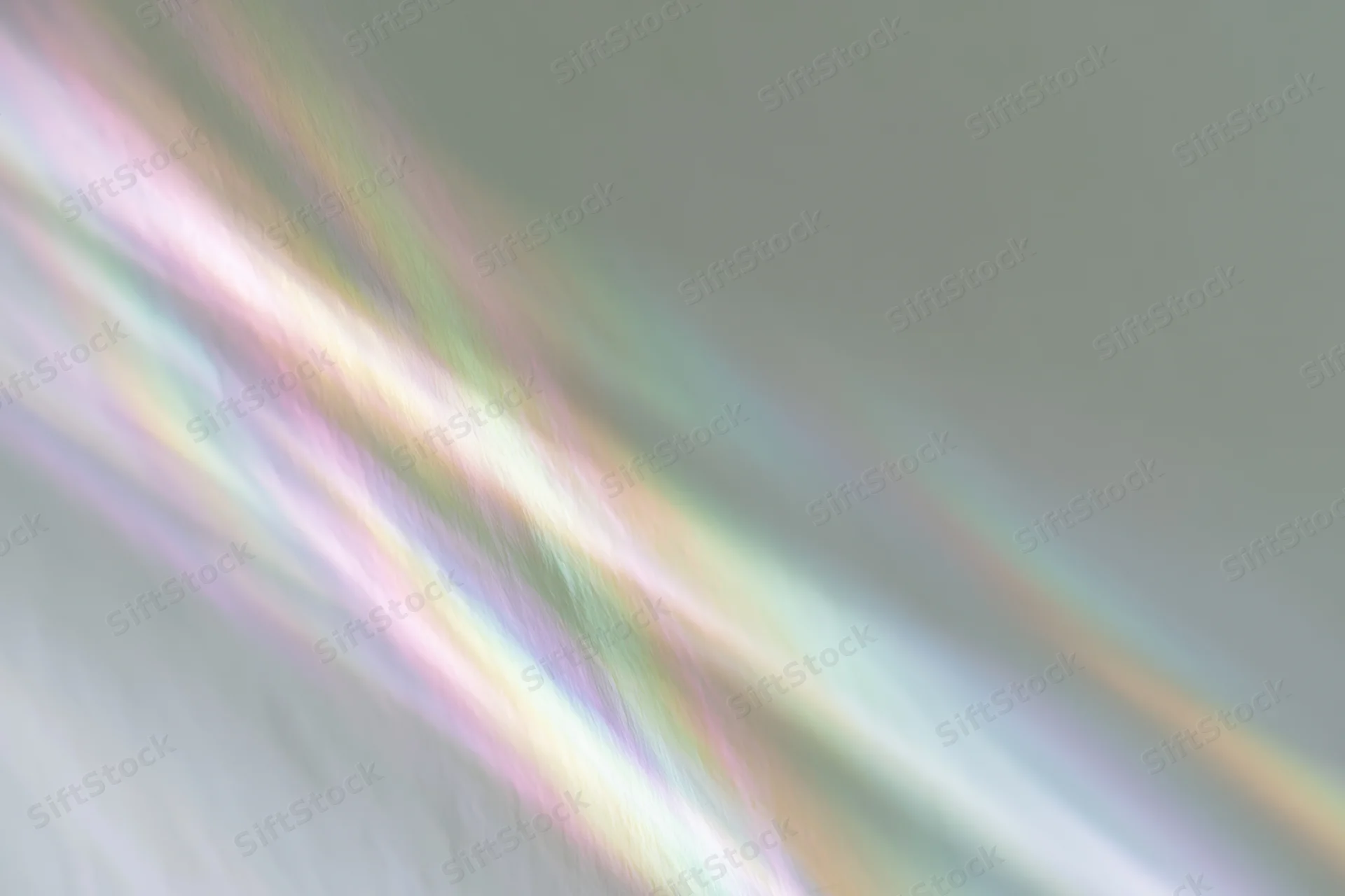 Rainbow light refraction streaks falling diagonally across a pale white background