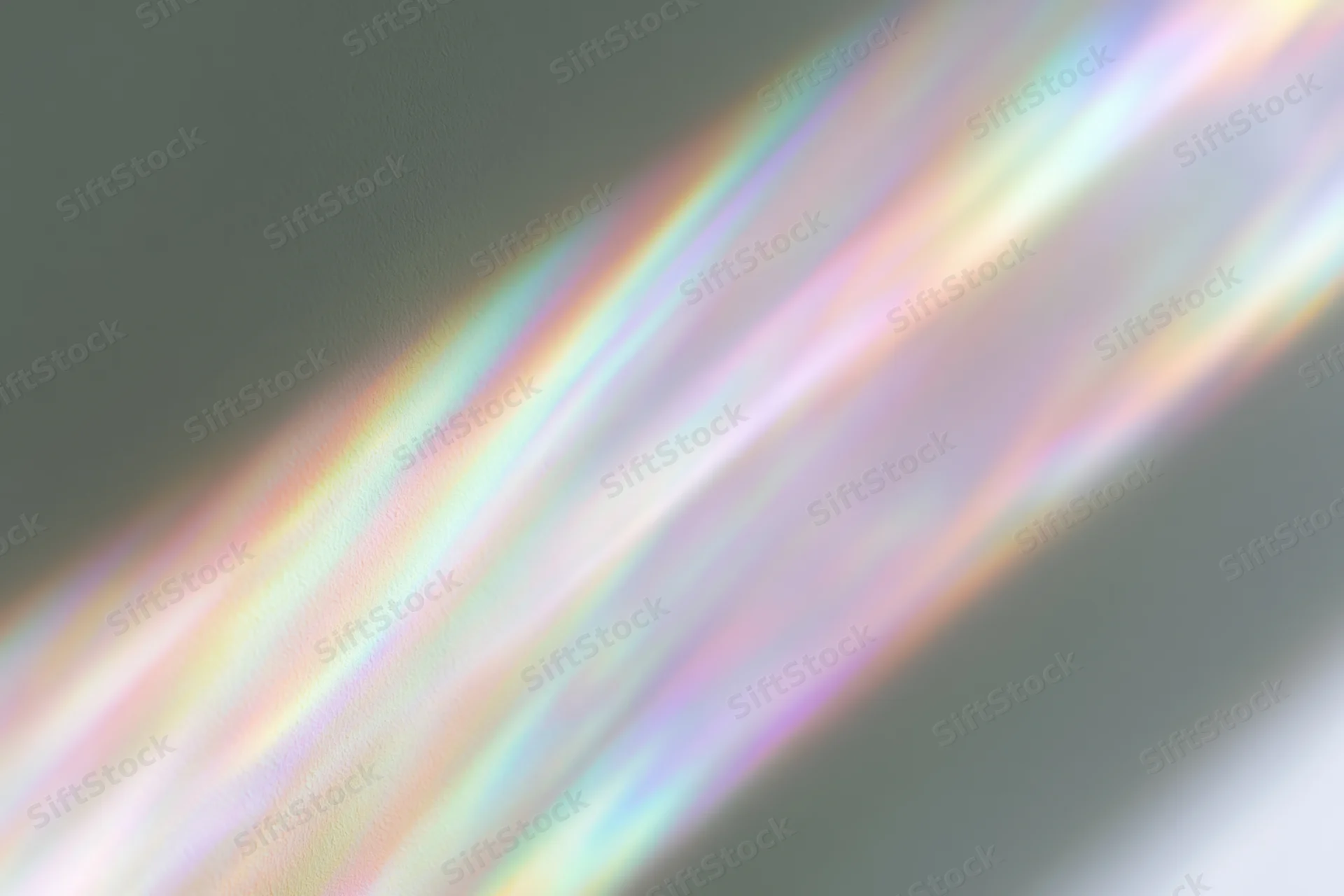 Rainbow light refraction streaks falling diagonally across a pale white surface