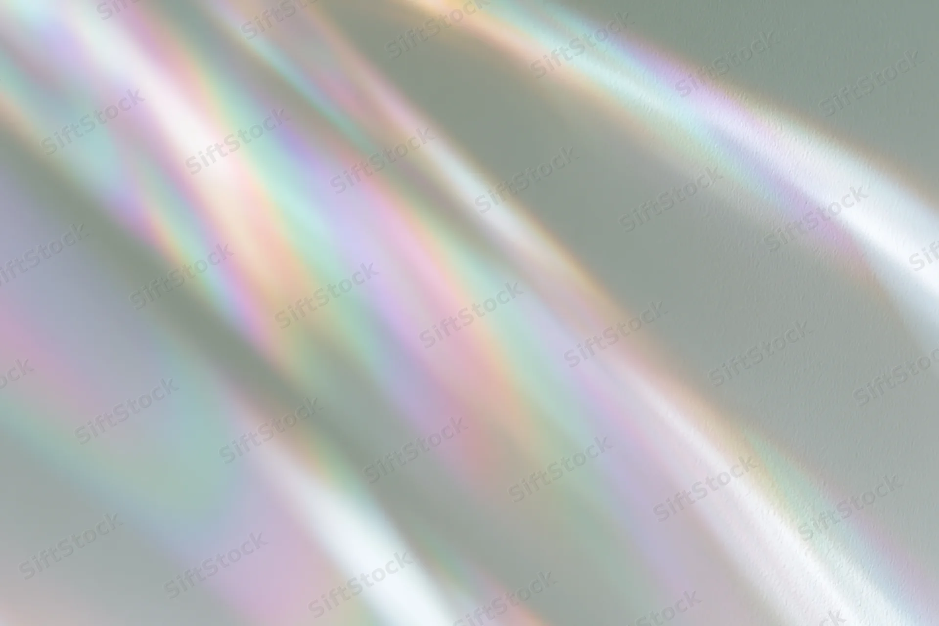Rainbow light refraction streaks falling across a pale white surface