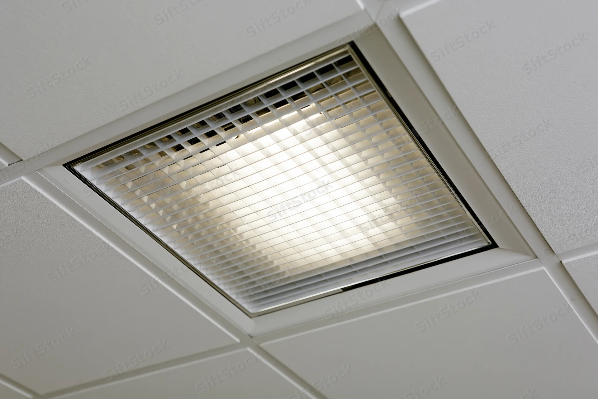 Recessed fluorescent grid light fixture mounted in a dropped ceiling tile system