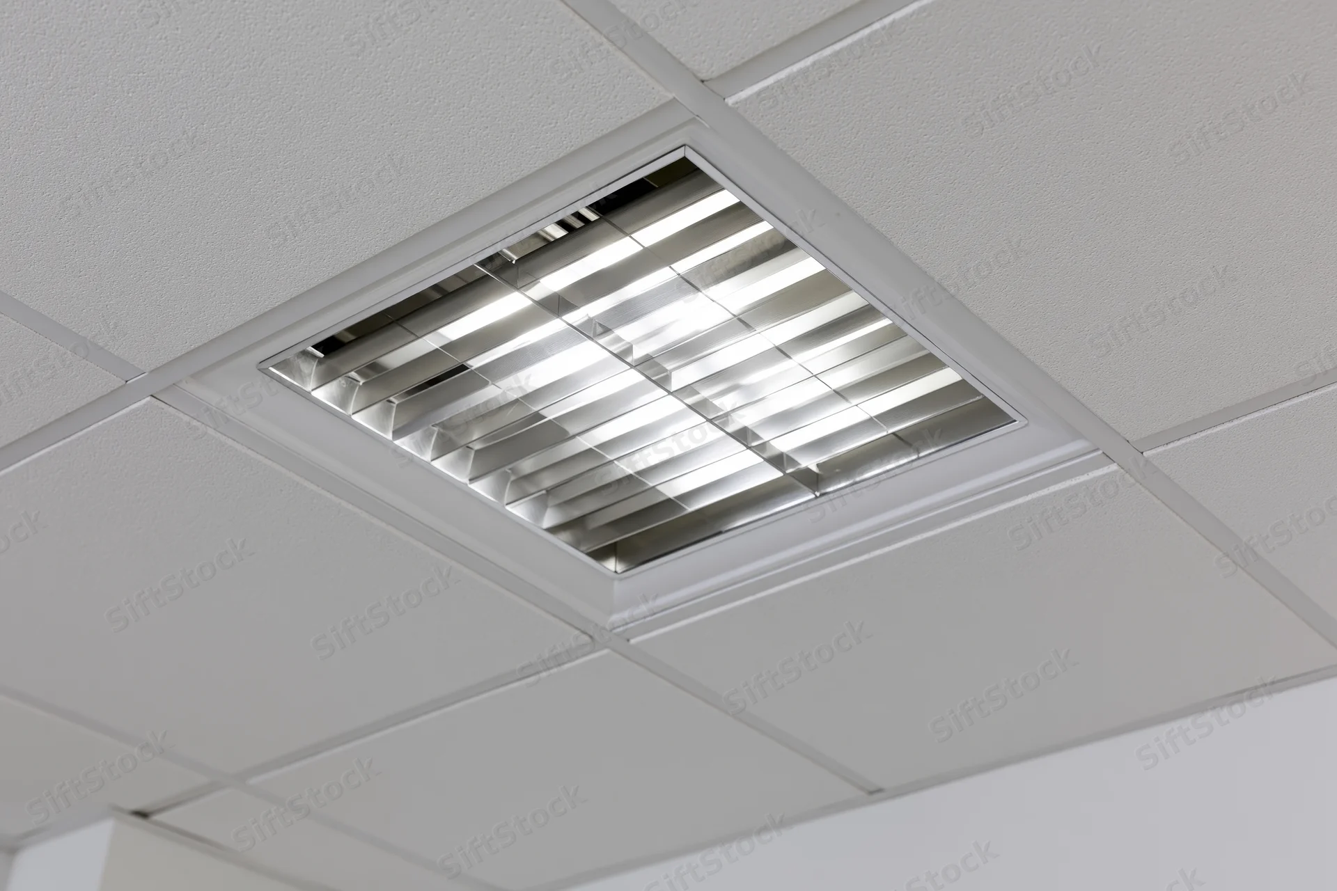 Recessed fluorescent grid light fixture mounted in a dropped ceiling tile system