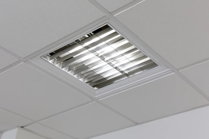 Recessed fluorescent grid light fixture mounted in a dropped ceiling tile system