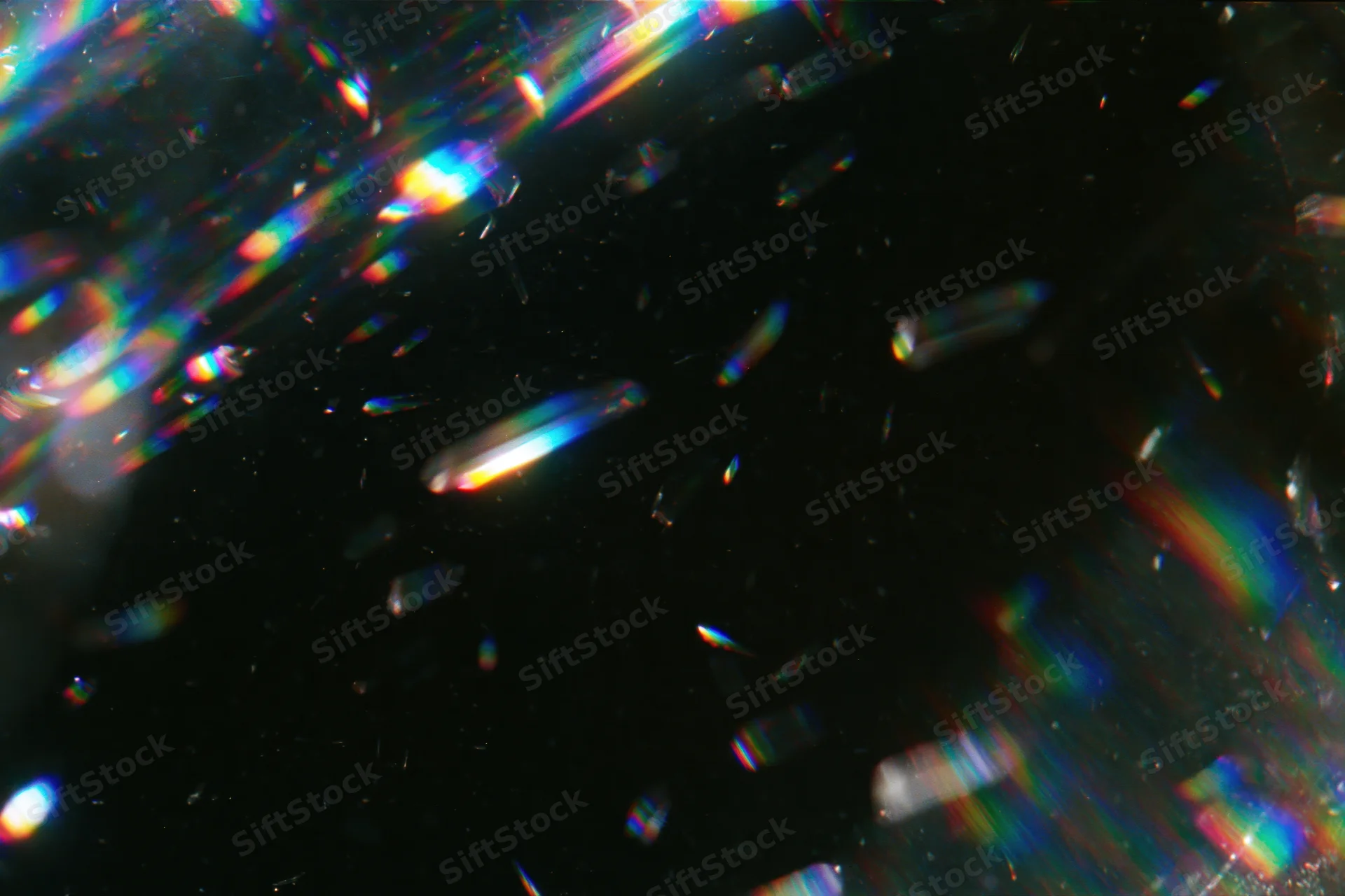 Scattered prismatic light refractions floating against a dark background