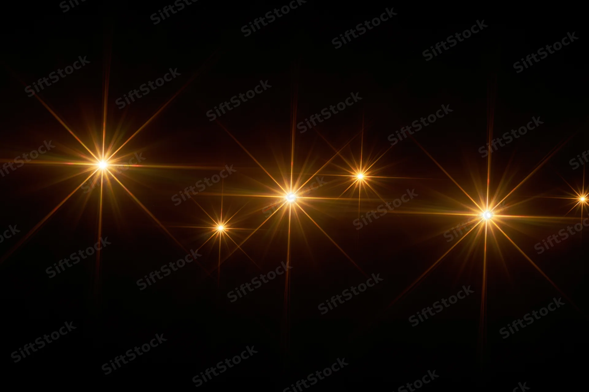 Golden lens flare star bursts scattered across a dark background