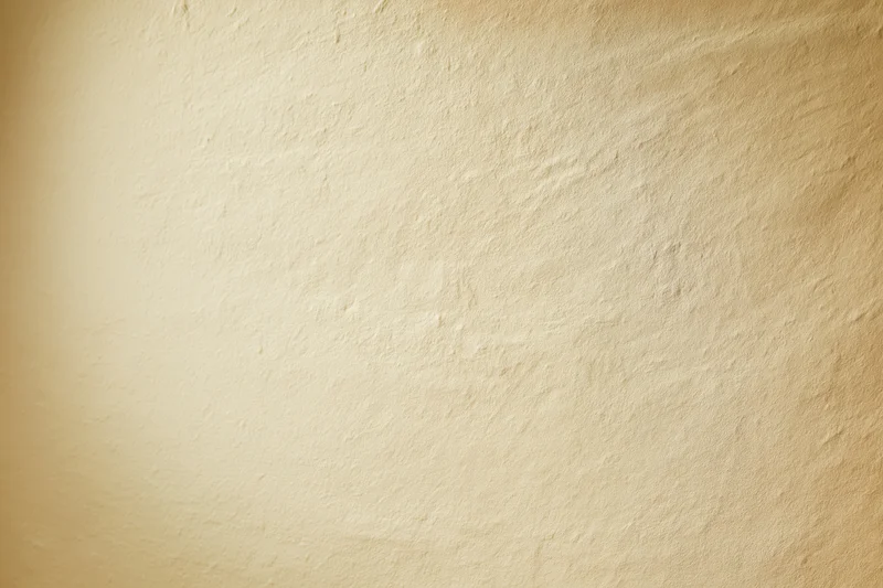 Smooth beige textured wall filling the frame as a studio backdrop