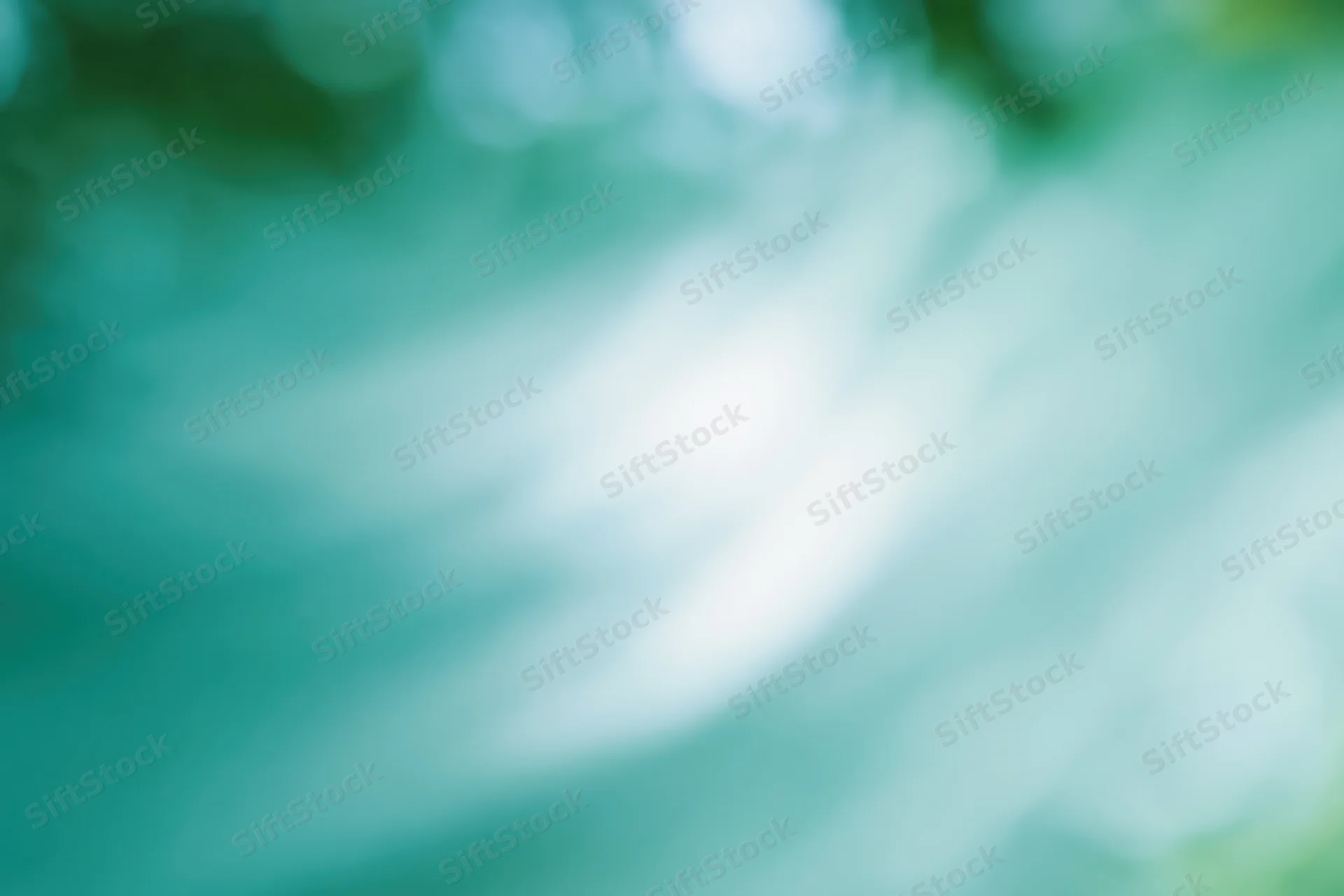 Soft abstract blurred background with bright white center and teal green gradient