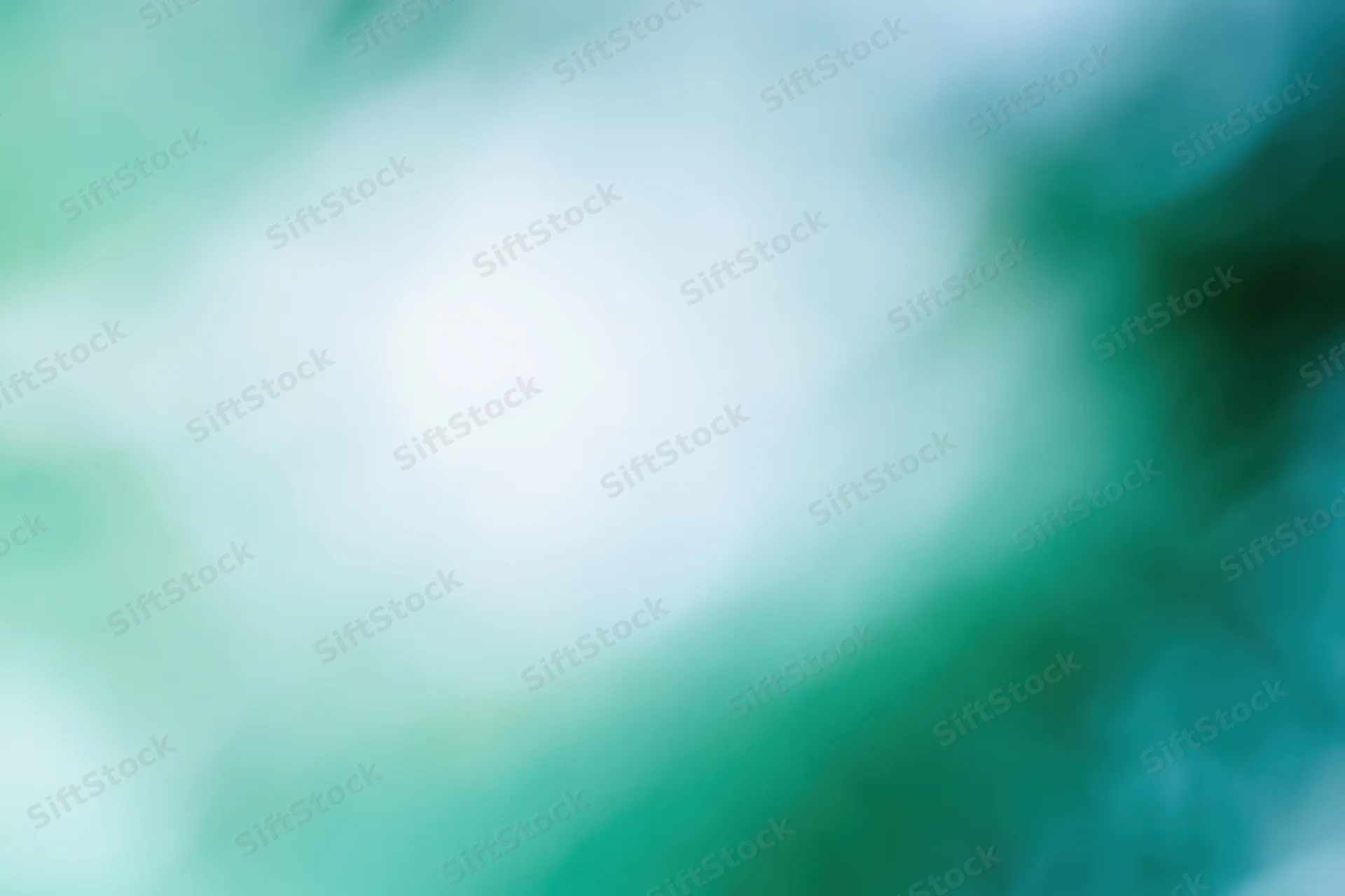 Soft blurred abstract background with bright white center and green teal gradients