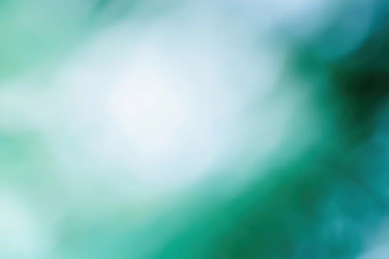 Soft blurred abstract background with bright white center and green teal gradients