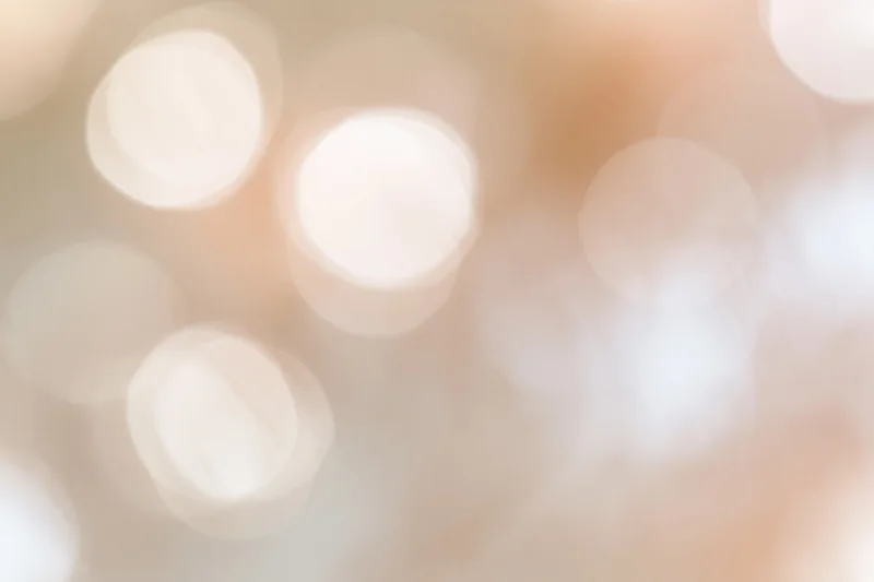 Soft abstract bokeh background with large out-of-focus lights in warm tones