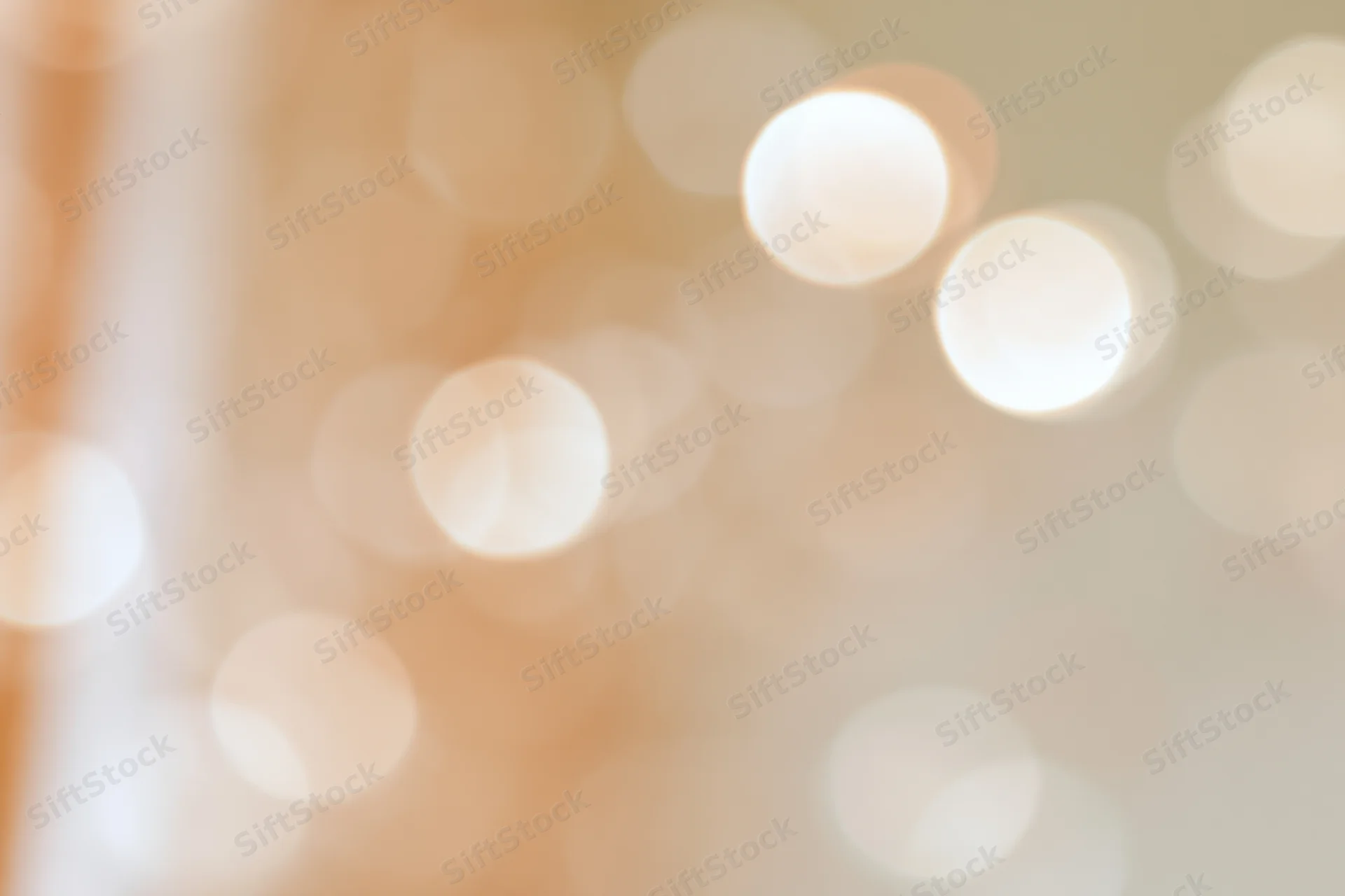 Soft abstract bokeh background with large out-of-focus lights in warm tones