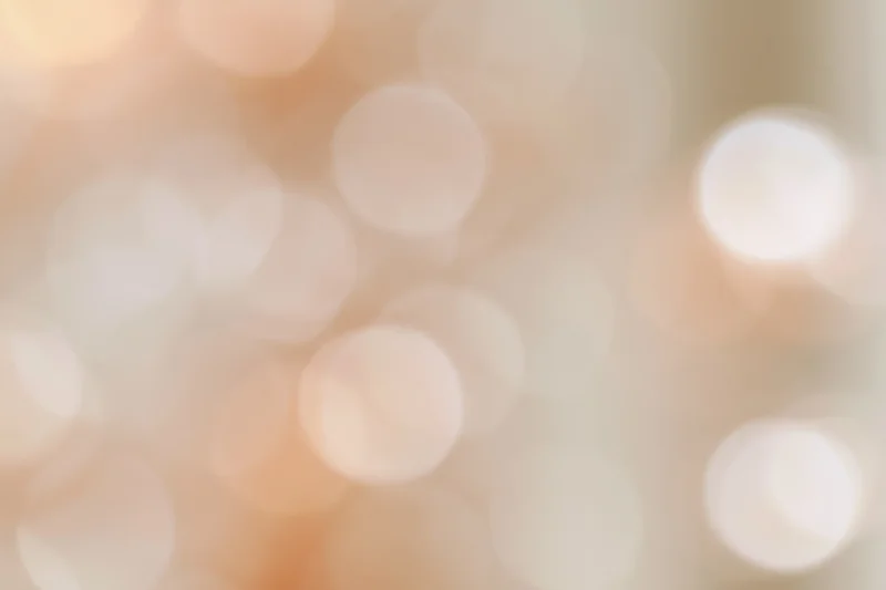 Soft abstract bokeh background with large out-of-focus lights in warm tones