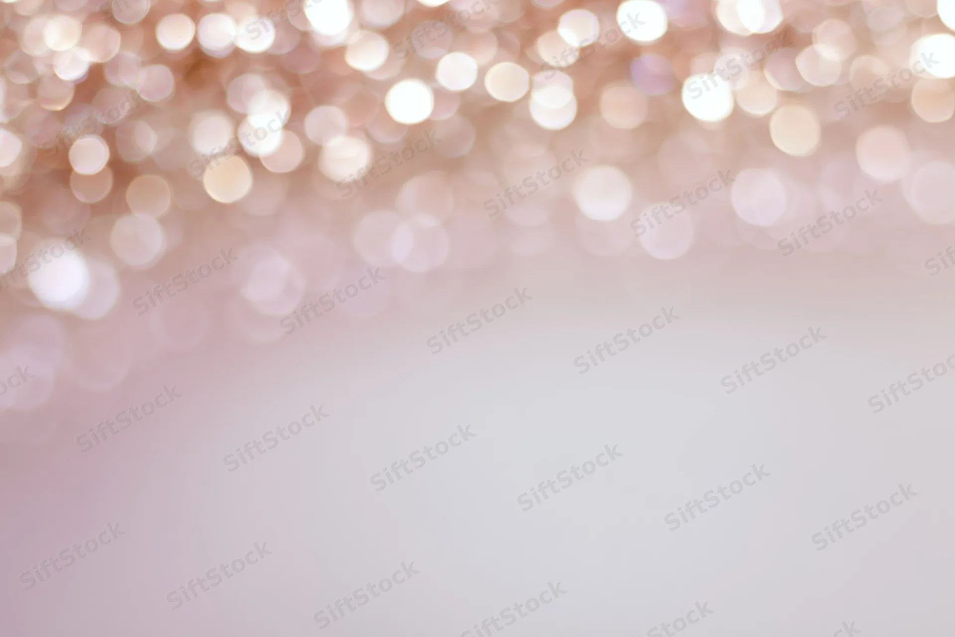 Soft abstract bokeh background with out-of-focus light orbs in pastel pink and white gradient, featuring copyspace at bottom