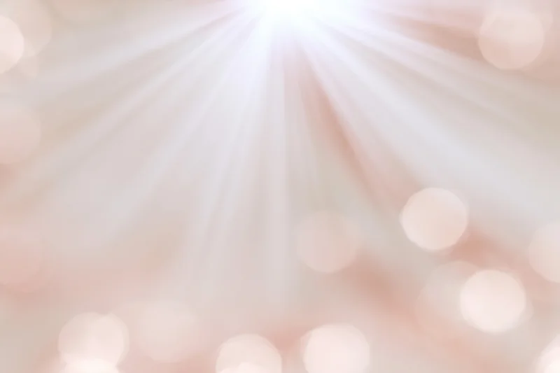 Soft blurred bokeh background with scattered circular lights in warm pastel tones