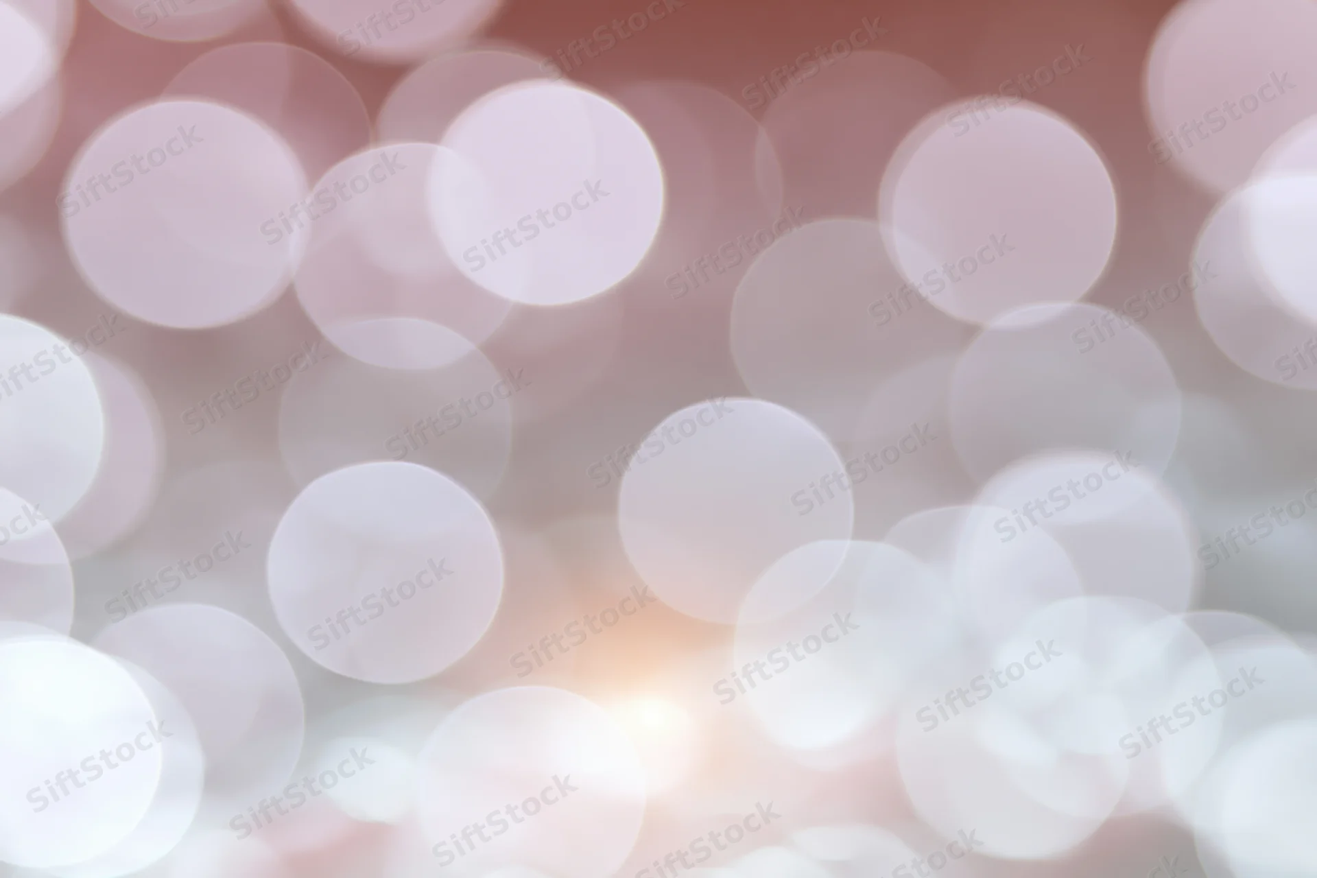 Soft bokeh background with large overlapping out-of-focus lights in warm pink and white tones