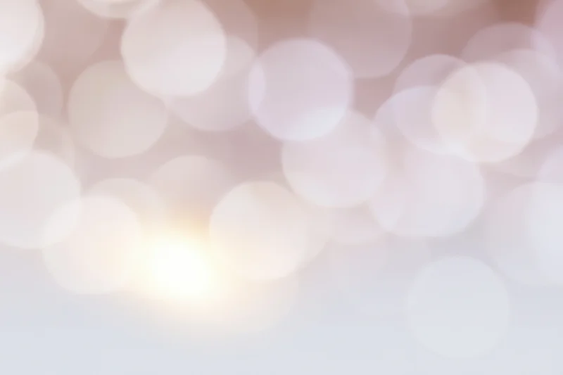 Soft bokeh background with large overlapping out-of-focus lights in warm pastel tones