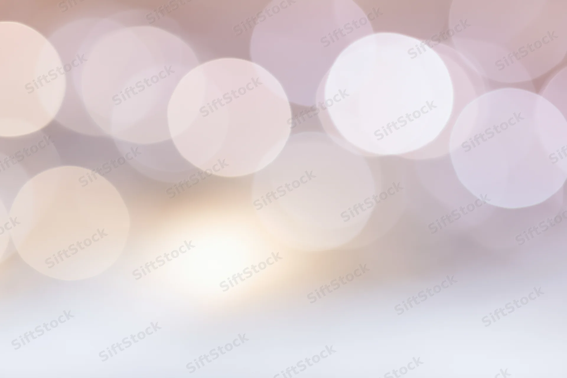 Soft bokeh background with large overlapping out-of-focus lights in warm pastel tones