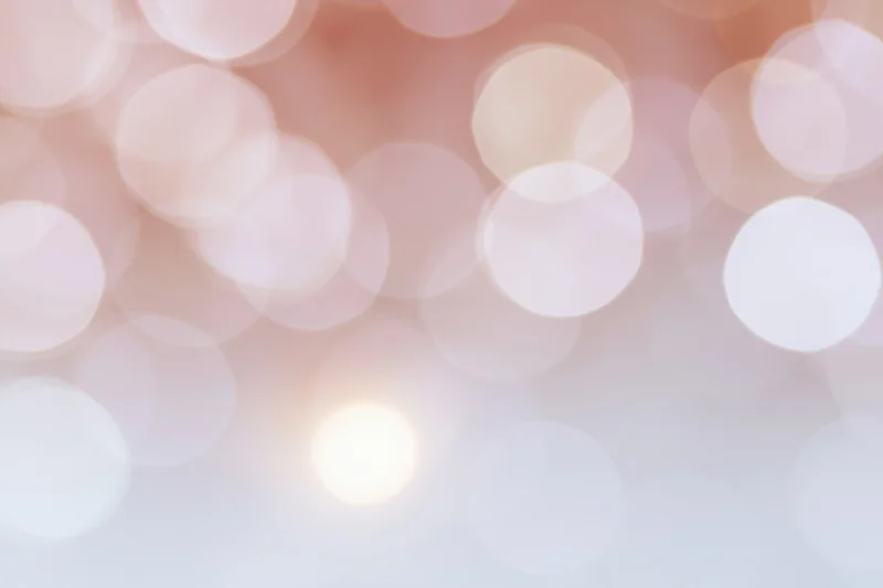 Soft bokeh background with large overlapping out-of-focus lights in warm pastel tones
