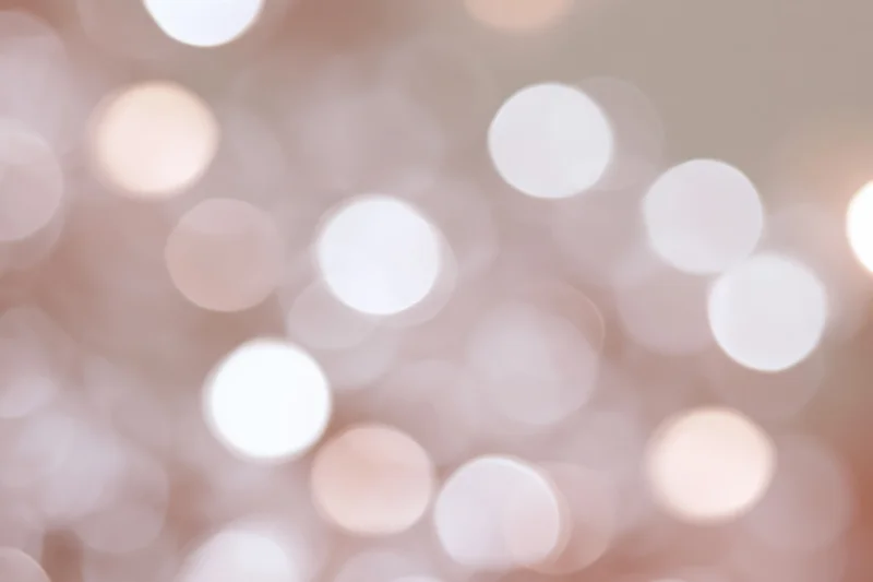 Soft out-of-focus white and pale pink bokeh lights forming a blurred background