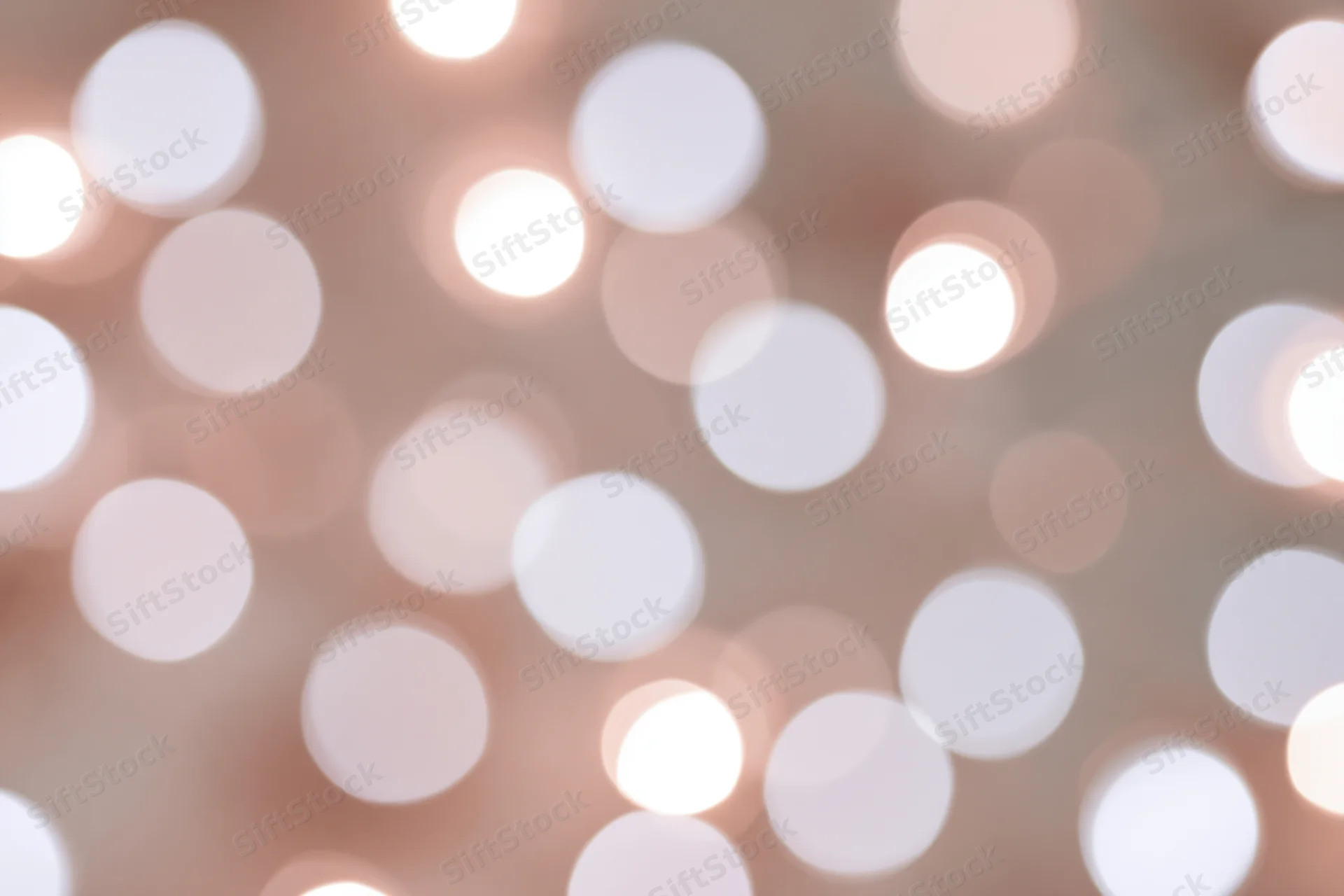 Soft out-of-focus white and pale pink lights arranged in a blurred background with circular bokeh effect
