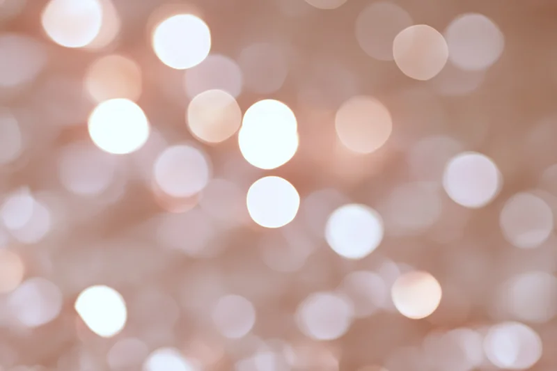 Soft out-of-focus white and pink bokeh lights forming a glowing abstract background